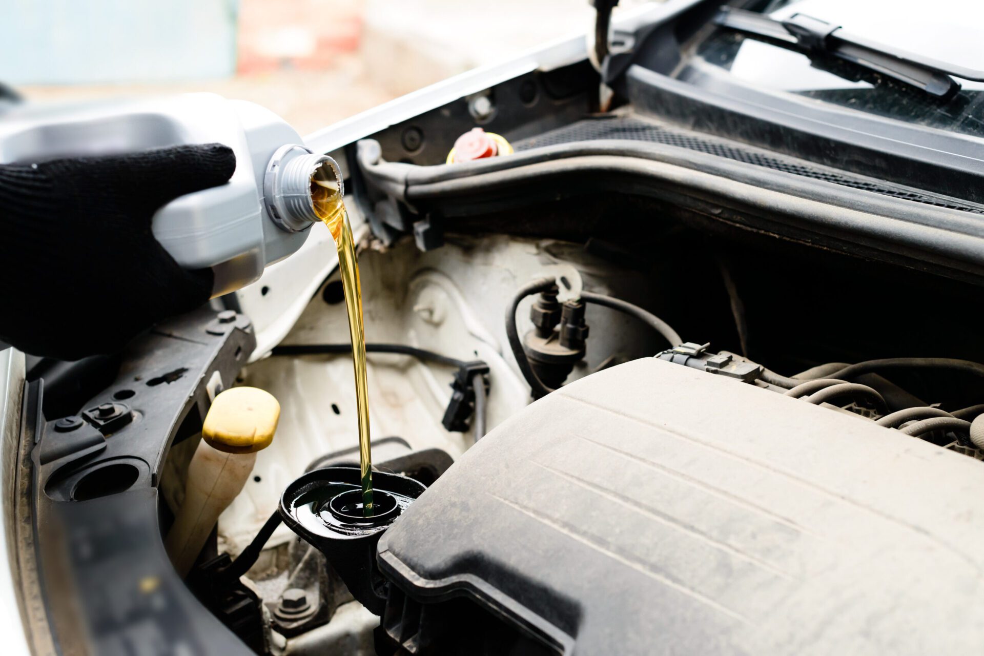 Fresh oil being poured during an oil change to car engine, close Fresh oil being poured during an oil change to car engine, close-up