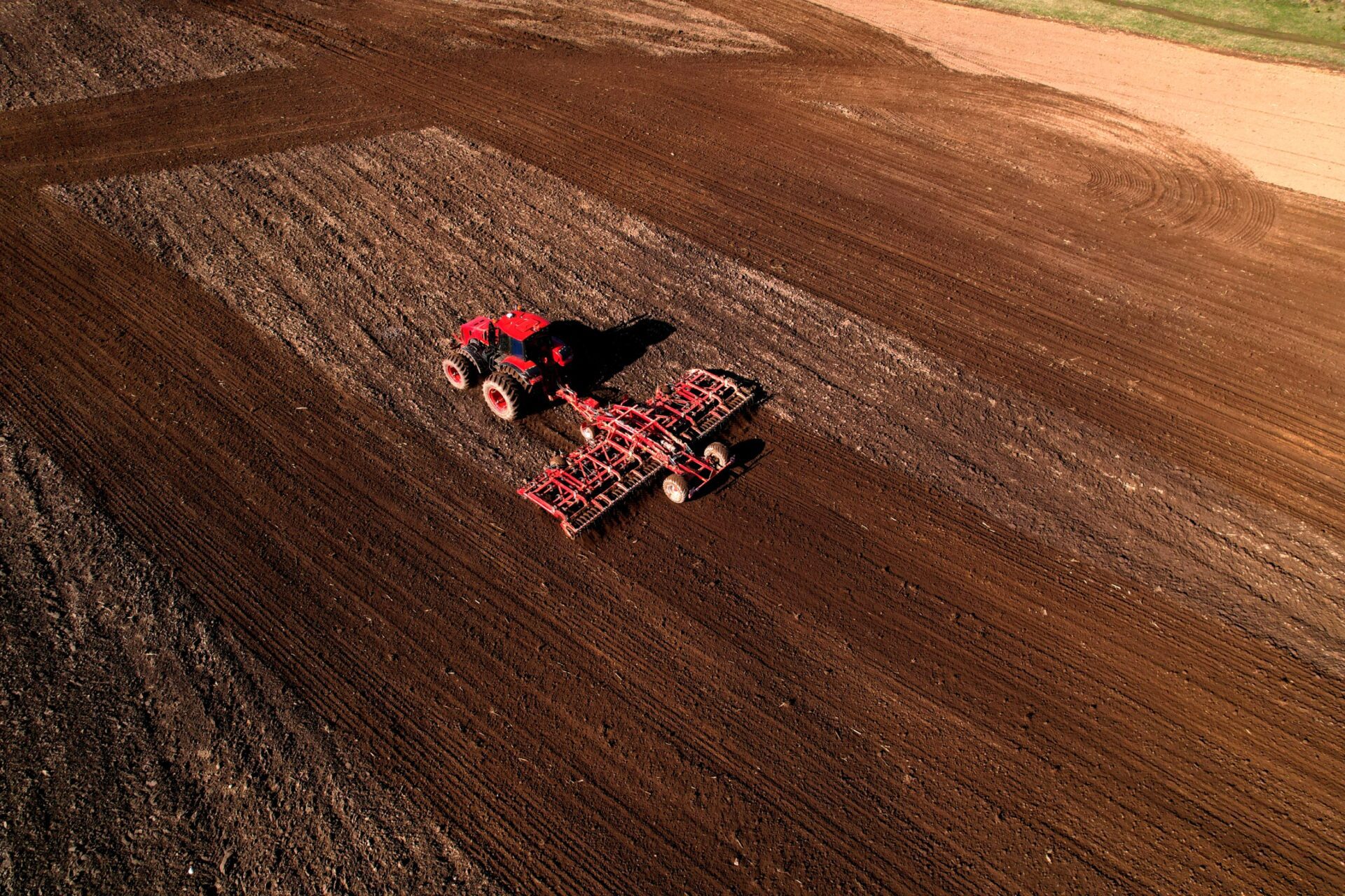 Tractor disk harrow on ploughing a soil. Sowing seed on plowed field on sunset. Tractor disk harrow on ploughing a soil. Sowing seed on plowed field on sunset.